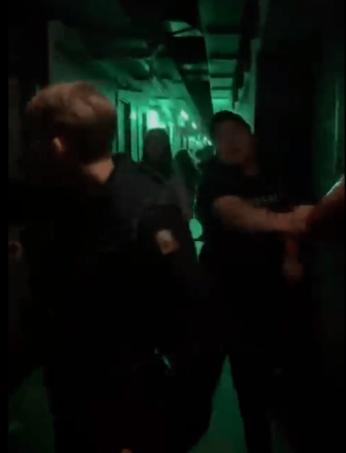 During The Clip, A Man In A Baseball Cap Rips A Fire Extinguisher Off The Wall And Stabs The Blonde, Who Walks Away.